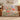 Poppy & Moth Reverie woven blanket draped over a brown leather sofa