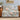 Magnolia & Swallows woven blanket draped over a brown leather sofa