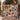 Couple holding a personalized Hearthside Christmas patchwork woven blanket with a sample family name by the Christmas tree
