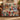 Hearthside Christmas patchwork woven blanket with fireplace, stockings and poinsettia patches draped over a leather sofa