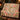 Hummingbird Blush Fountain Garden woven blanket draped over a sofa in a warm living room