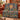 Balloon Valley Sun Medallion woven blanket draped over a rust sofa
