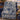Blue Cream Hanukkah Story woven blanket draped over a navy armchair beside a table of sufganiyot