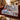 Blue Willow Pheasant Christmas woven blanket draped over a sofa in a holiday living room