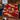 Christmas Pudding Supper woven blanket draped over a navy sofa