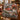 Christmas Tree Farm Red Truck woven blanket draped over a leather sofa by a fireplace