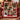 Christmas Wreath Ring photo blanket with eight family photos and a blank name ribbon draped over a red armchair