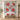 Personalized Crimson Solstice Poinsettia quilt with custom family name hung on a wall above a bench with 2 matching pillowcases