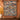 Denim Terracotta Balloon Valley Pattern woven blanket displayed as a wall tapestry on a terracotta wall above a wooden console