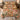 Floral Patchwork Golden Terracotta quilt bedding set with 2 matching pillowcases on a bed in a cozy bedroom