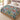 Four Kingfishers Waterlily Garden woven blanket spread across a bed in a cozy bedroom