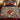 Glasshouse Poinsettia Noel Christmas woven blanket spread across a bed in a holiday bedroom