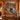 Golden Hour Tamarack Moose Lake woven blanket displayed as a wall tapestry on a log cabin wall above a wooden console