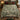 Green Cream Red Deer Christmas woven blanket spread on a bed with red and green pillows