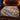 Grosbeak Hemlock Alpenglow woven blanket spread across a bed in a cozy bedroom