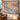 Grosbeak Hemlock Alpenglow woven blanket hanging as a wall tapestry beside an armchair