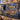 Hanukkah Eighth Night Window woven blanket draped over a blue sofa with menorah pillows