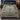 Hanukkah Tree of Light woven blanket spread on a bed with navy and olive pillows