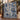 Indigo Hanukkah Lamps Around the World woven blanket draped over a staircase banister with blue garland