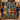 Nativity Stained Glass Window fleece blanket draped over a navy armchair