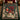 Navy Nutcracker Pomegranate woven blanket spread on a bed with forest green bedding