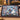 Personalized Painterly Blue Christmas Grove woven blanket with custom family name draped over a sofa by a Christmas tree