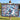 Painterly Blue Christmas Grove woven blanket held up outdoors by a lake