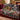 Peaceable Kingdom Starlight Path woven blanket with custom family name draped over a sofa, holiday room view