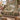 Cream Sage Stream woven blanket draped over a sofa or armchair