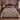 Lavender Flying Geese botanical woven blanket spread across a bed