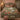 Terracotta Garden River botanical woven blanket spread across a bed