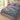 The Herb Bed Diagonal botanical woven blanket spread across a bed