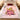 Pink Grinch Ribbon Christmas fleece blanket spread on a bed