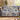 Personalized The Unhurried Chapter blue toile woven blanket draped over a green velvet sofa