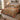 Tupelo Coral Canopy quilt bedding set on a bed in a cozy bedroom, coral and sage woodland foliage