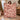 Yuletide Keepsake Patchwork woven blanket in burgundy held up beside a Christmas tree, burgundy red and warm ivory patchwork with Santa, snowman and toy train