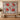 Crimson Solstice poinsettia woven blanket hung as a Christmas wall tapestry with sample family name
