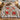Crimson Solstice poinsettia woven blanket spread across a bed with plaid pillows