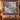 Passionflower Swallowtail Garden quilt hung on a wall with sample family name The Caldwell Family above a bench with 2 matching pillowcases