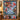 Christmas Bell Garden quilt hung on a wall with sample family name The Whitaker Family above a bench with 2 matching pillowcases
