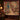 Raccoon Pawpaw Curio Study woven blanket hanging as a wall tapestry beside an armchair