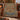 Red Deer Tree of Life woven blanket draped over a rust sofa by a fireplace