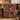 Red Navy Christmas Pudding woven blanket draped over a green velvet sofa