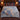 Snow Leopard Blue Poppy Pass Luxe woven blanket spread across a bed in a cozy bedroom