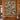 Spruce Rust Tamarack Moose Lake Pattern woven blanket displayed as a wall tapestry on a log cabin wall above a wooden console