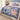 Swallow Iris Ribbon Ballet woven blanket spread across a bed in a cozy bedroom