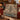Twin Reindeer Bell Spruce woven blanket draped over a red sofa by a fireplace