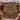 Victorian Christmas Toy Cabinet woven blanket draped over a red sofa with plaid pillows
